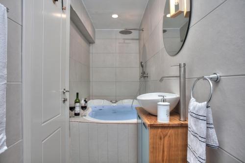 a bathroom with a tub and a sink and a mirror at סוויטת גן עדן - Gan Eden Suite in Safed