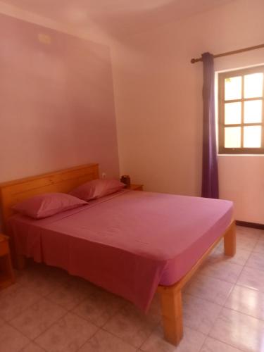 a bedroom with a bed with a red blanket on it at Aldeia Jerome in Paul