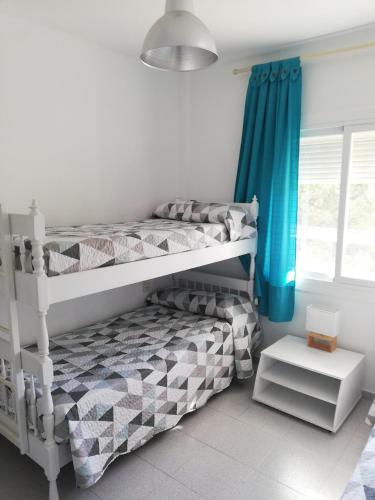 a bedroom with two bunk beds and a window at Bosmar Bosc 5-A in Pals