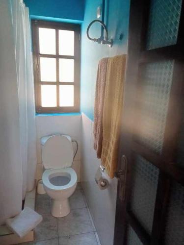 a bathroom with a toilet and a window at Aldeia Jerome in Paul