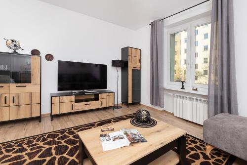 a living room with a television and a coffee table at Władysława IV Studio for 4 guests Gdynia by Renters in Gdynia