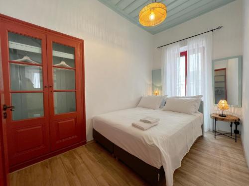 1 dormitorio con 1 cama con puerta roja en Archipelagos by halu!, en Skiathos