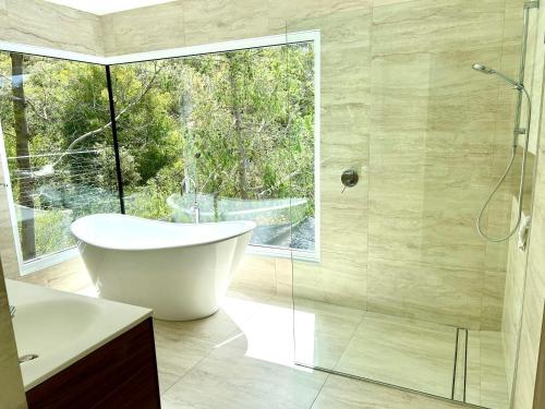 a bathroom with a tub and a glass shower at Sandy Bay Haven in Sandy Bay