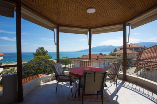 eine Terrasse mit einem Tisch und Stühlen auf dem Balkon in der Unterkunft Villa Amalia Sun Beach in Nea Vrasna