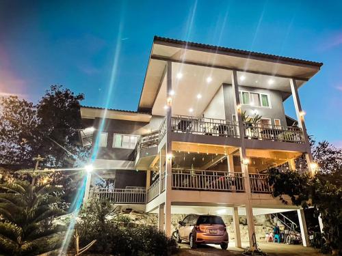 een huis met een auto ervoor geparkeerd bij บ้านบนภู ปากช่อง พลูวิลล่า - with a housekeeper in Ban Lam Thong Lang