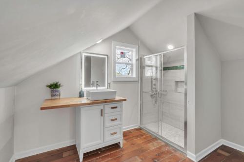 a white bathroom with a sink and a shower at 4Bed/3bath- 1 mile to Downtown in Spartanburg