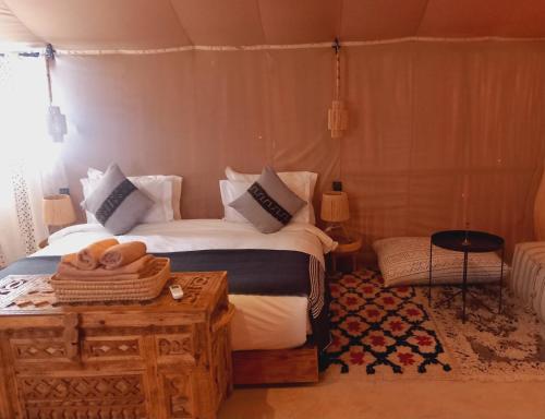 um quarto com uma cama e uma mesa com toalhas em Night sky luxury camp em Adrouine