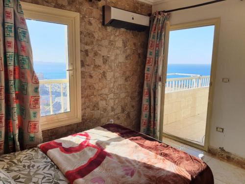 een slaapkamer met een bed en een groot raam bij City Square - Brand New Luxury Apartment With Stunning Sea View in Alexandrië