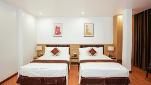 um quarto de hotel com duas camas num quarto em Khách sạn Lam Anh Ngoại Giao Đoàn Hà Nội em Hanói