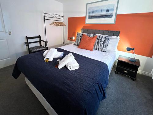 um quarto com uma cama grande e toalhas em Hindmarsh Apartment em Ashington