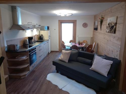 a living room with a couch and a kitchen with a table at Hennleiten Hof in Reith bei Kitzbühel