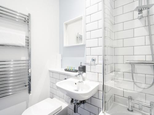 a white bathroom with a sink and a shower at Pass the Keys Unique Grade II Listed Flat in Liverpool Parking in Knowsley