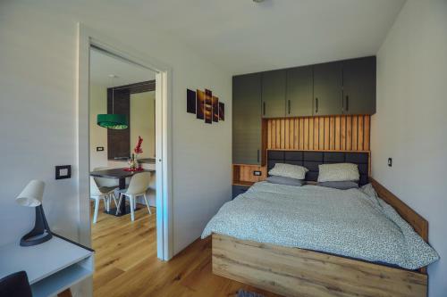 1 dormitorio con 1 cama con cabecero de madera y mesa en Apartma Vitalis, en Smarjeske Toplice