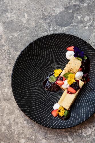 a black plate with food on a table at Home Suite Hotels Rosebank in Johannesburg