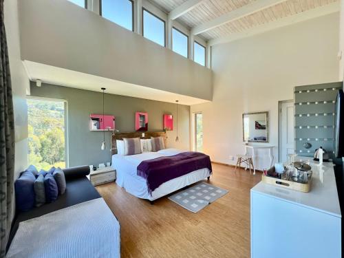 a bedroom with a large bed and a large window at Pure Guest House in Hout Bay