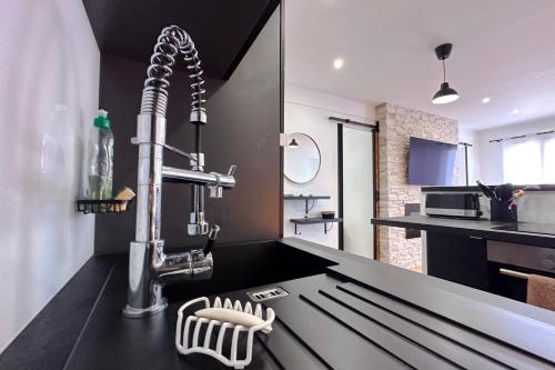 une cuisine avec un comptoir noir et un évier dans l'établissement BELLET - Rooftop, jacuzzi et vue imprenable sur Nice et Mer, à Nice