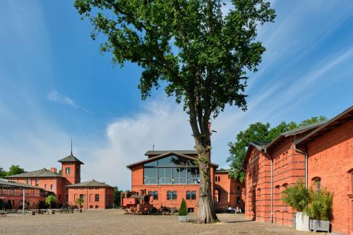 a tree in front of a brick building at Landgut Stober in Groß Behnitz