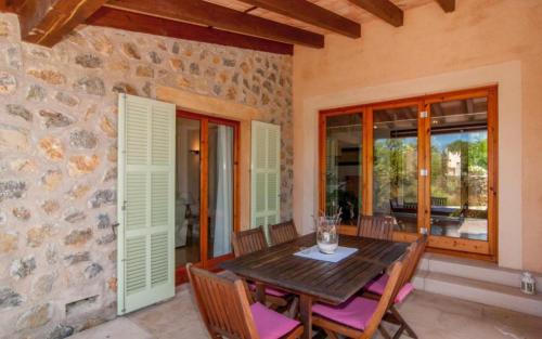 a dining room with a wooden table and chairs at Es Romagueral in Artá
