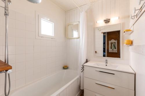 ein Badezimmer mit einer weißen Badewanne und einem Waschbecken in der Unterkunft Villa Cap Ferret - Réf 230 in Lège-Cap-Ferret