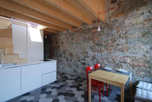 cocina con mesa, sillas y pared de ladrillo en La Casa Della Zia, en Sarnico