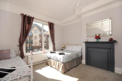 1 dormitorio con cama y ventana en Loveliest Homes Paignton - Wavecrest Apartments - mixed sizes - parking, en Paignton