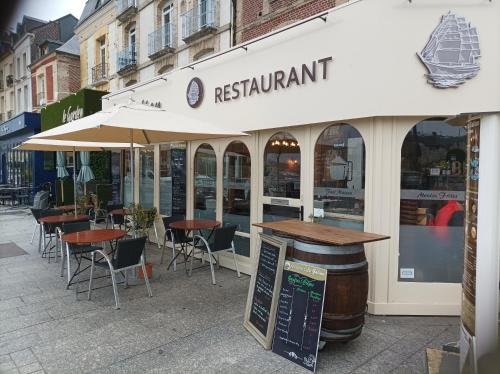 un restaurante con mesas y sillas en una calle en Près des etoiles, en Dieppe