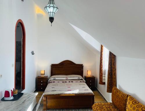 um quarto com uma cama e 2 cadeiras em Dar Fatima em Chefchaouen