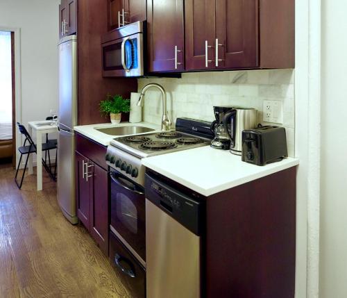 Il comprend une cuisine équipée d'une cuisinière et d'un évier. dans l'établissement Cozy FamilyFriendly Apartment with 2 Bedrooms, à New York