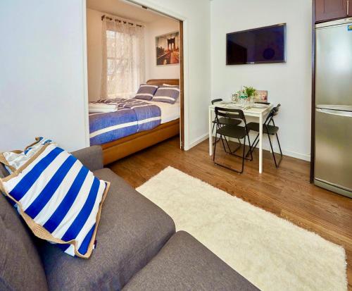 紐約的住宿－Cozy FamilyFriendly Apartment with 2 Bedrooms，带沙发、床和桌子的客厅
