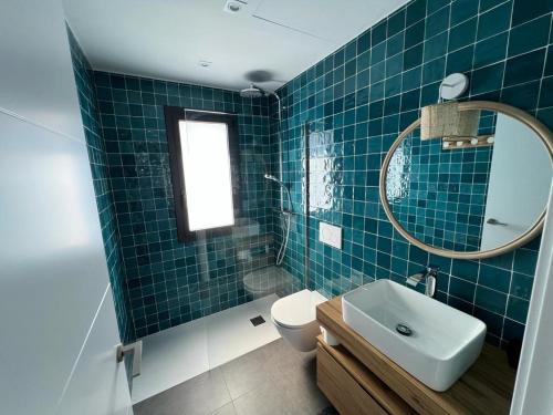 ein Badezimmer mit einem WC, einem Waschbecken und einem Spiegel in der Unterkunft Casa Isabelle Caials in Cadaqués
