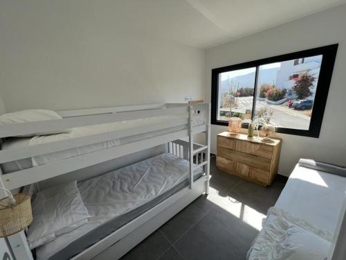 1 Schlafzimmer mit 2 Etagenbetten und einem Fenster in der Unterkunft Casa Isabelle Caials in Cadaqués