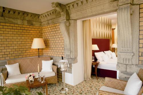 a hotel room with two beds and a couch at Hotel Villa Sanct Peter in Bad Neuenahr-Ahrweiler
