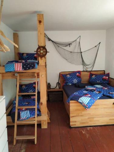 a bedroom with two bunk beds and a ladder at Sandburg in Zempin