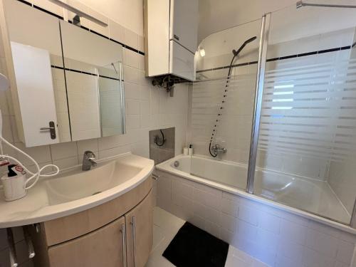 a bathroom with a sink and a tub and a shower at Elegant 2+1 BR Apt at Vienna's Vibrant 3. District in Vienna