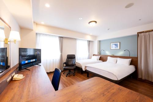 横須賀市にあるホテルニューヨコスカのベッド2台、薄型テレビが備わるホテルルームです。