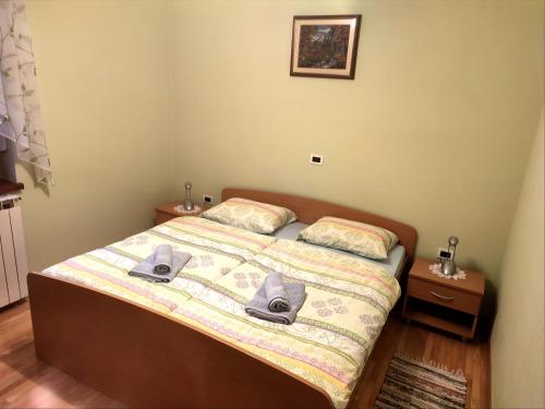 a bedroom with a bed with two hats on it at Apartma pod Rožem in Soča