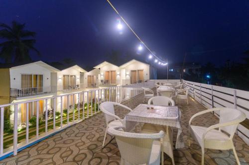 a table and chairs on a balcony at night at Tvessa - A Boutique Hotel in Mandrem