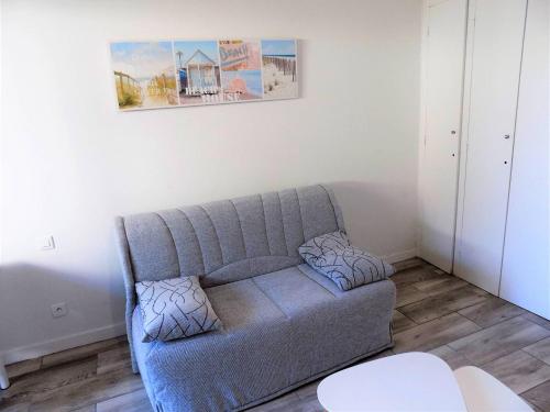 - un canapé dans le salon avec une photo sur le mur dans l'établissement Royan - JOLI NID DOUILLET - résidence MINERVE - proche commerces et plages, à Royan