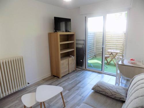un salon avec un canapé et une télévision dans l'établissement Royan - JOLI NID DOUILLET - résidence MINERVE - proche commerces et plages, à Royan