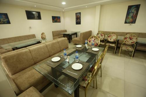 uma sala de jantar com uma mesa e um sofá em Hotel Orchid & Banquet em Agra