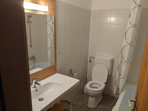 bagno con servizi igienici bianchi e lavandino di Gasthof mit Seeterasse & Appartements Zur Landeroith a Weyregg