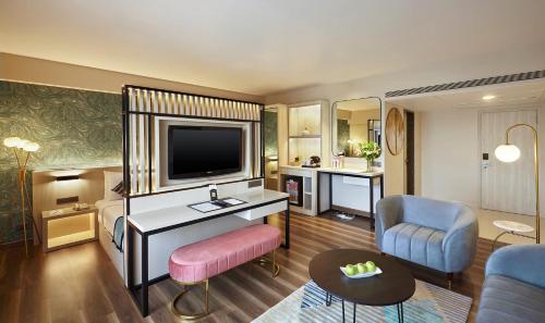 a hotel room with a bed and a television at Hotel Suba International Sahar Road Mumbai in Mumbai
