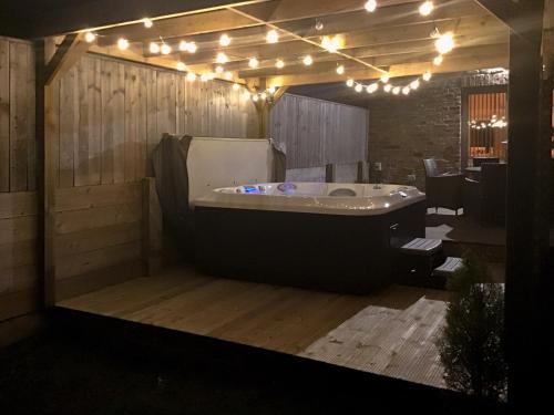 a large bath tub in a room with lights at The Cart Shed in Witton Gilbert