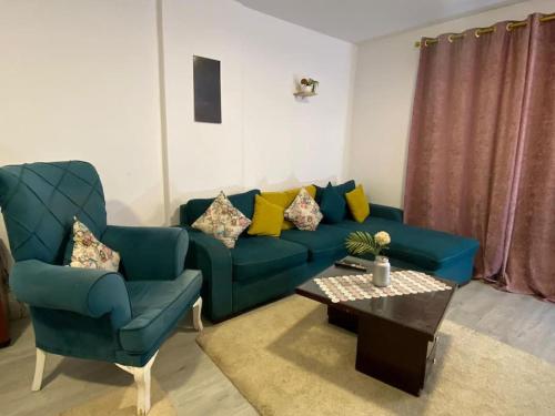 a living room with a blue couch and a coffee table at Rehab serenity in Cairo