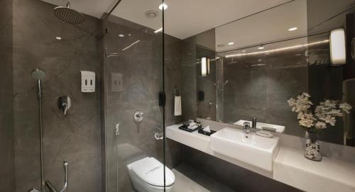a bathroom with a toilet and a sink and a shower at Hotel Suba International in Mumbai