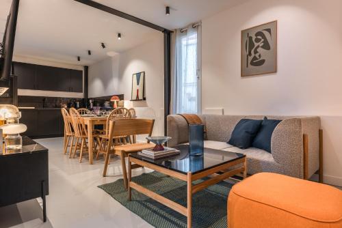 ein Wohnzimmer mit einem Sofa und einem Tisch in der Unterkunft Design Architect Flat - 15min. from Paris center in Gentilly