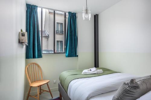 a bedroom with a bed and a chair and a window at Design Architect Flat - 15min. from Paris center in Gentilly