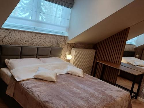 a bedroom with a large bed with a large window at Apartamenty u Roxi in Jelenia Góra