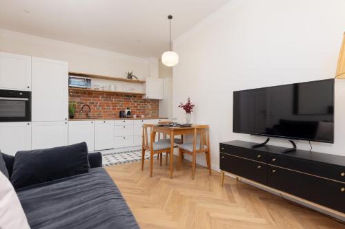 a living room with a table and a large television at Warsaw Pruszków Park View Comfortable Apartments by Noclegi Renters in Pruszków