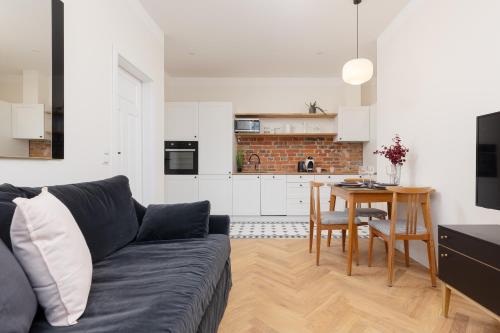 a living room with a couch and a table and a kitchen at Warsaw Pruszków Park View Comfortable Apartments by Noclegi Renters in Pruszków